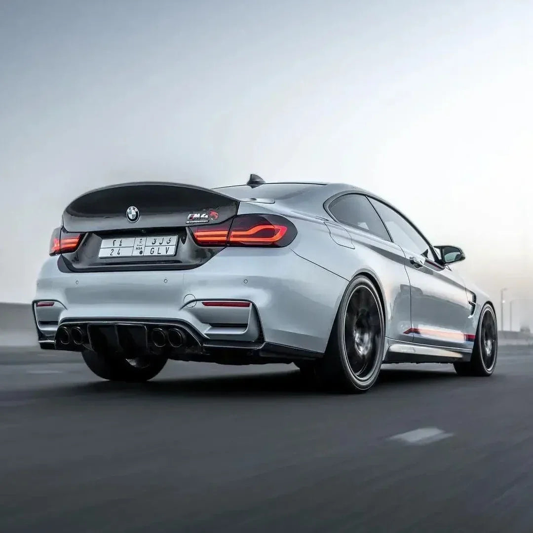 Silver BMW F82 M4 CS shot on the move, with carbon trunk lid, rear three-quarter view (CSL Style)