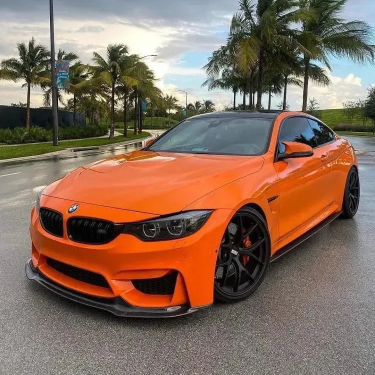 Orange BMW F82 M4 with fitted carbon side skirts, three-quarter front view (MP Style)