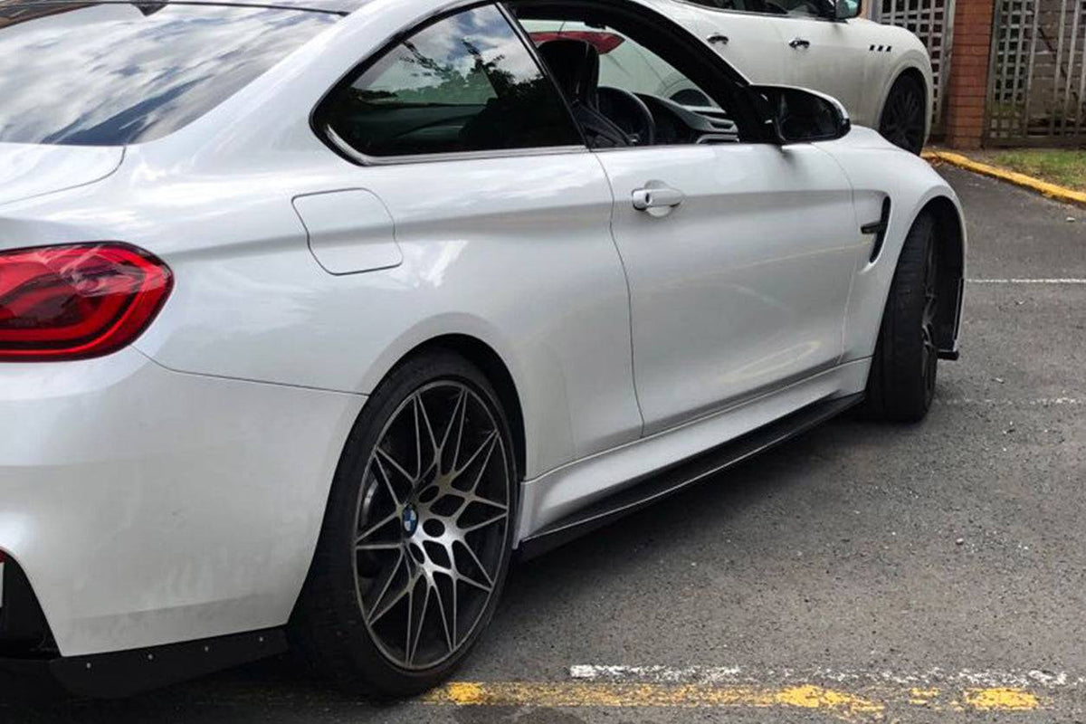 White BMW F82 M4 in rear-side three-quarter view, with fitted carbon side skirt (VA Style)