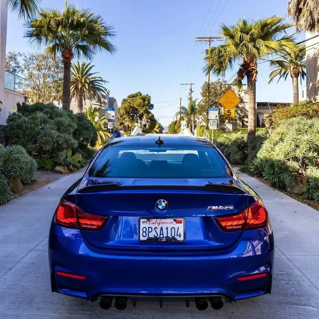 Rear of a blue BMW F82 M4 CS parked on the street, with carbon trunk spoiler (CS Style)