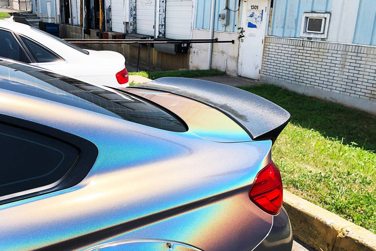 Holographic BMW F82 M4 rear three-quarter close-up with carbon ducktail spoiler (DE Style)