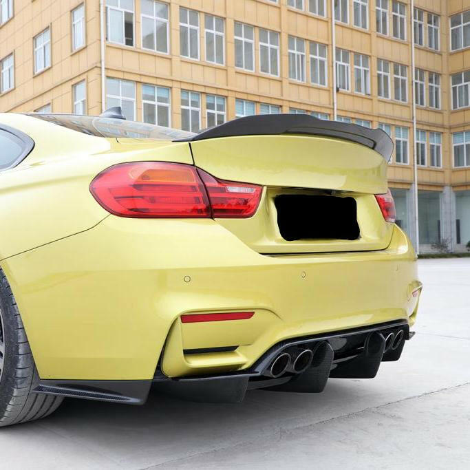 Yellow BMW M4 in rear three-quarter view, with fitted carbon trunk spoiler (PSM Style)