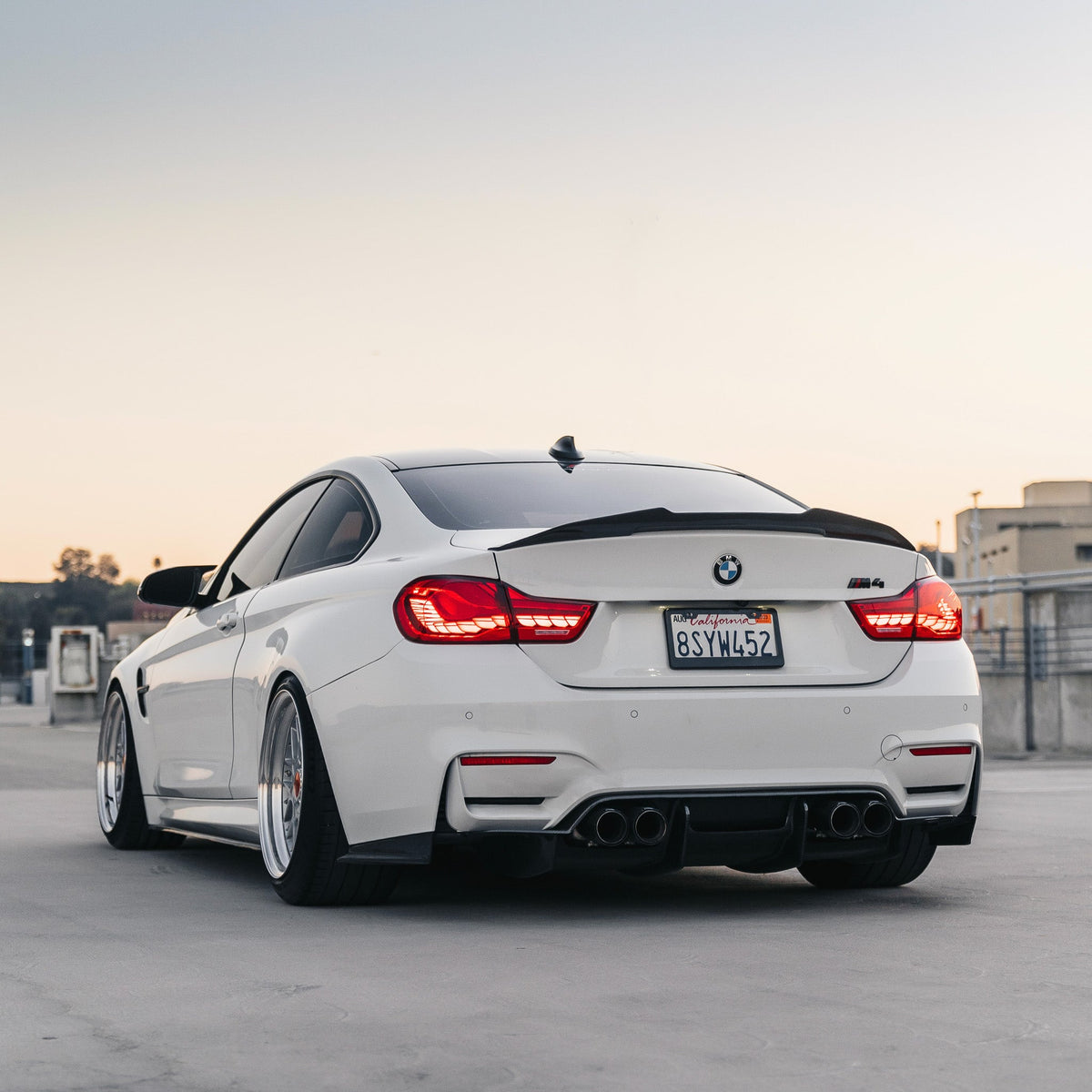 White BMW M4 rear view, with fitted carbon high kick trunk spoiler (PSM Style High Kick)