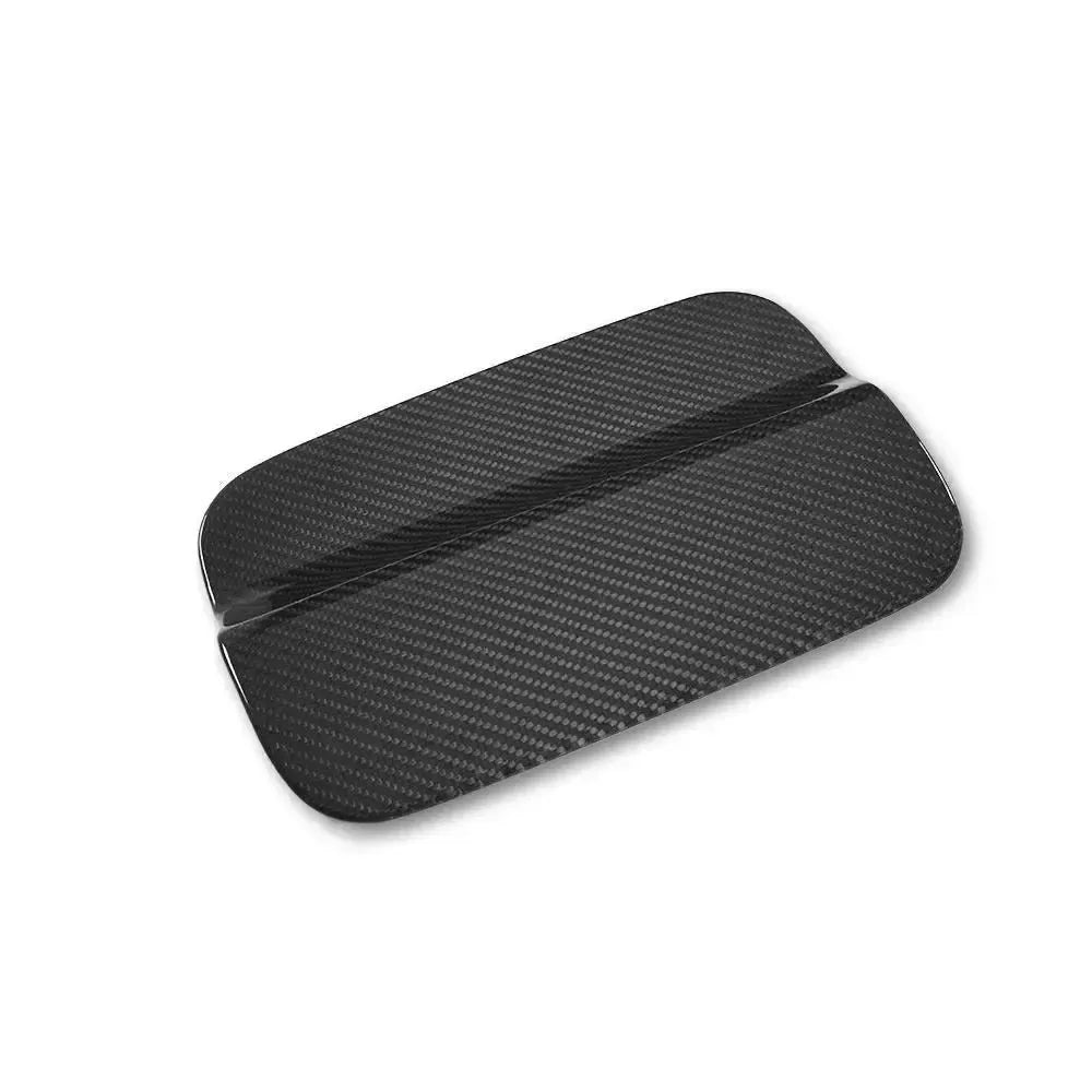 Carbon fiber fuel cap cover, angled view, on a white background – BMW F82 M4 / F83 M4