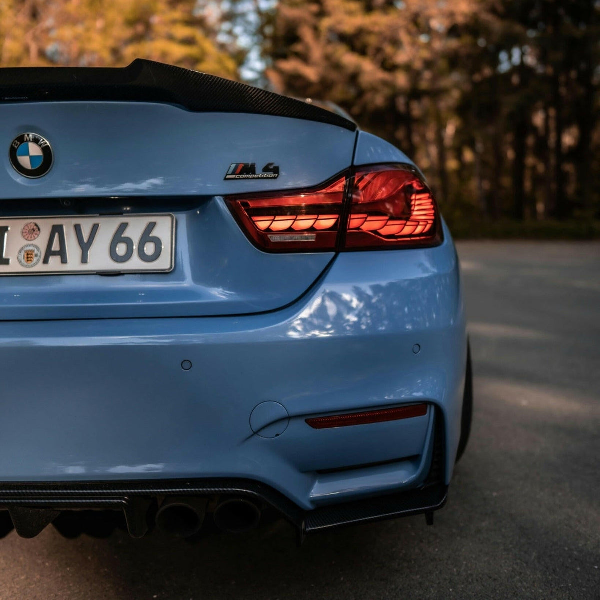 Light blue BMW M4 rear close-up, with illuminated red sequential OLED tail light (GTS Style)