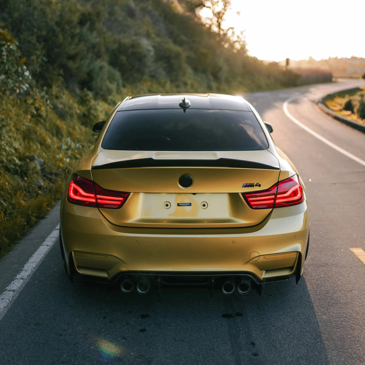 Gold BMW F82 M4 rear view on the road, with LED tail lights (LCI Style)