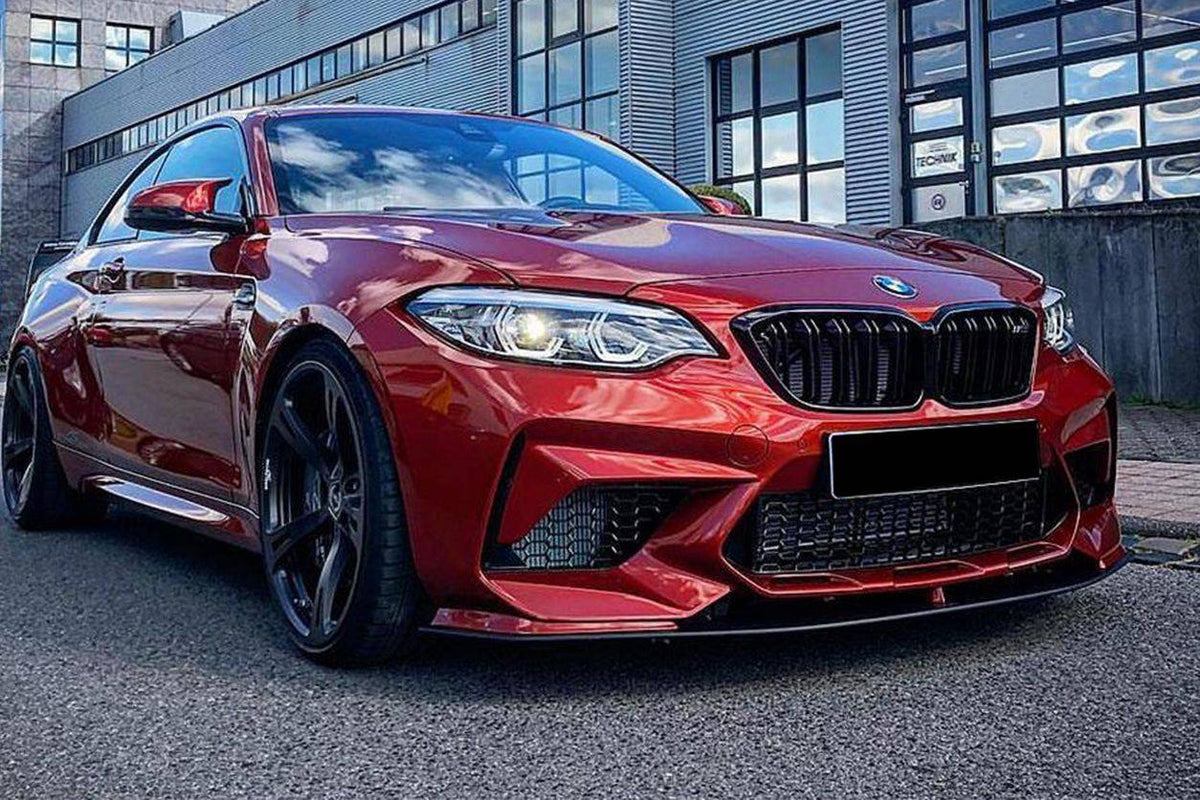 Narancssárga BMW F87 M2 Competition elölről ferdén, felszerelt AC Style carbon első koptatóval