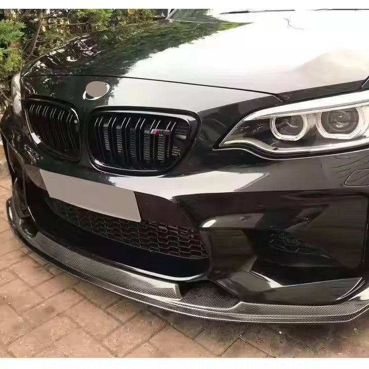 Fekete BMW F87 M2 eleje közelről, felszerelt MTC Style carbon első koptatóval