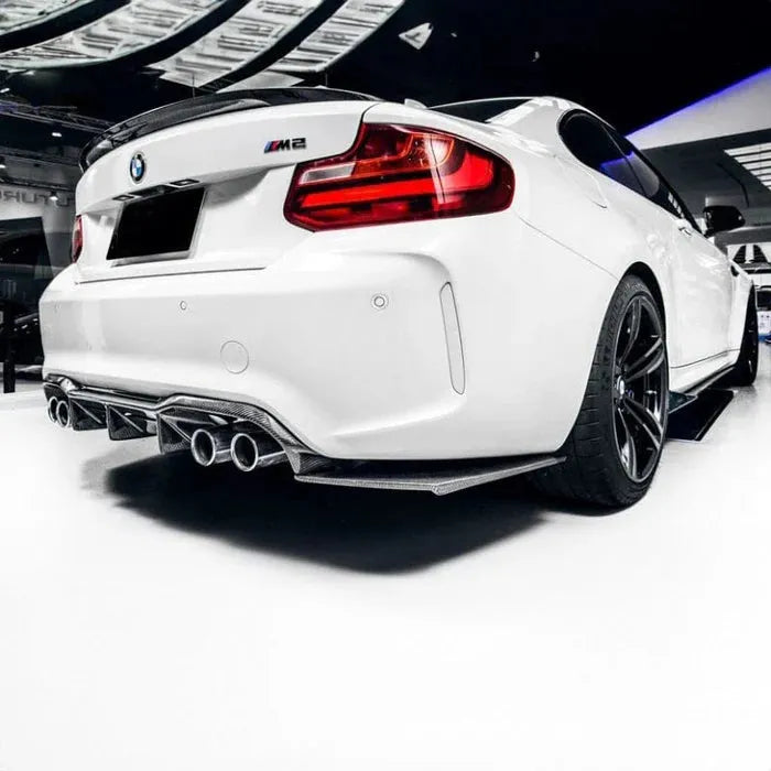 Fehér BMW F87 M2 hátulról ferdén szalonban, felszerelt MTC Style carbon diffúzorral és splitterekkel
