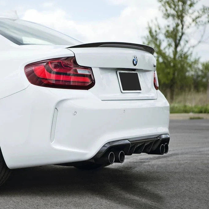 White BMW F87 M2, angled rear view, with Performance Style carbon diffuser and carbon spoiler