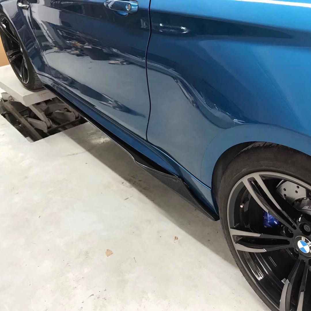 Blue BMW F87 M2 on a lift with MTC Style carbon fiber side skirt extensions
