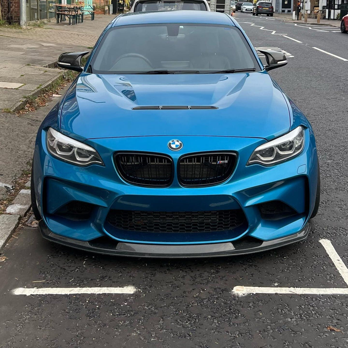 Kék BMW F87 M2 szemből, felszerelt dupla lamellás carbon vesével