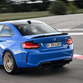 Kék BMW F87 M2 CS hátulról ferdén versenypályán, felszerelt CS Style carbon spoilerrel