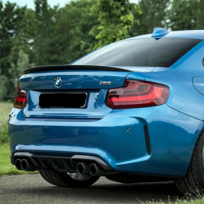 Kék BMW F87 M2 hátulról ferdén, felszerelt MP Style carbon spoilerrel