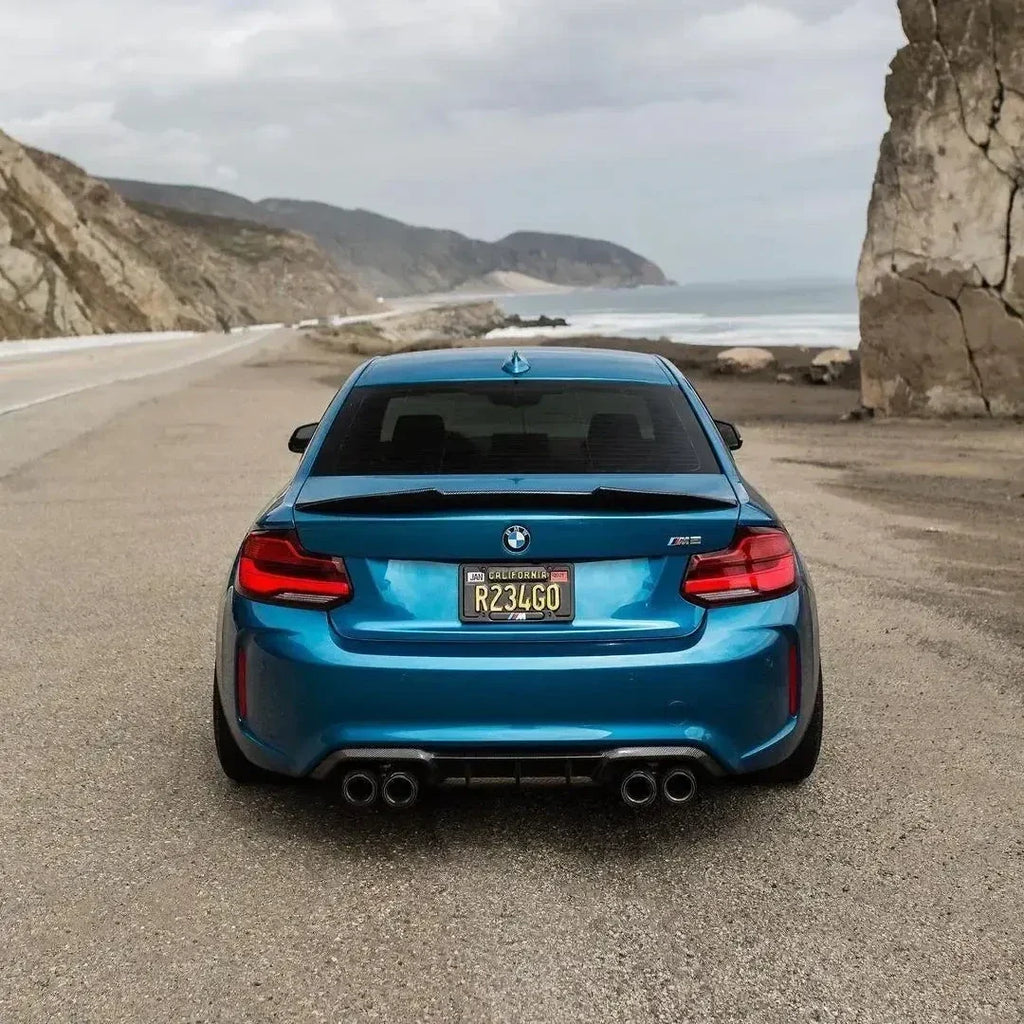 Kék BMW F87 M2 hátulról tengerparti úton, felszerelt PSM Style carbon spoilerrel
