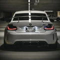 Fehér BMW F87 M2 hátulról parkolóban, világító GTS Style OLED hátsó lámpákkal