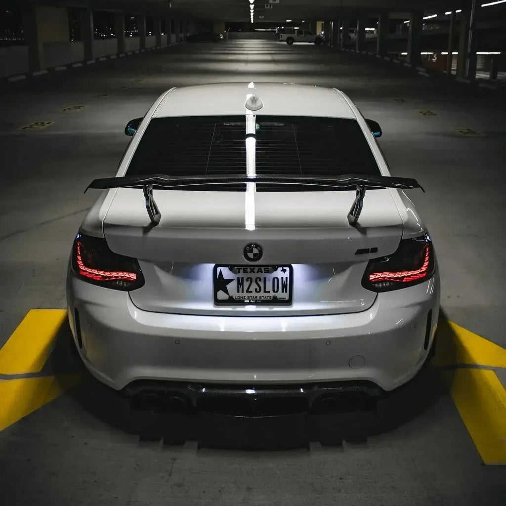 Fehér, hátsó szárnyas BMW F87 M2 hátulról, világító GTS Style OLED hátsó lámpákkal