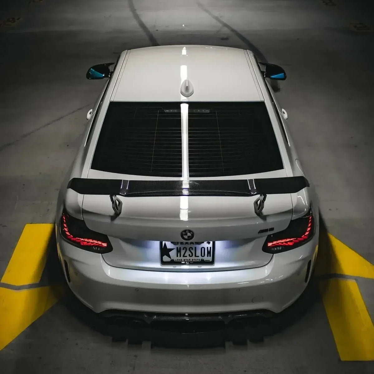 Fehér BMW F87 M2 hátulról, magasról fotózva, világító GTS Style OLED lámpákkal