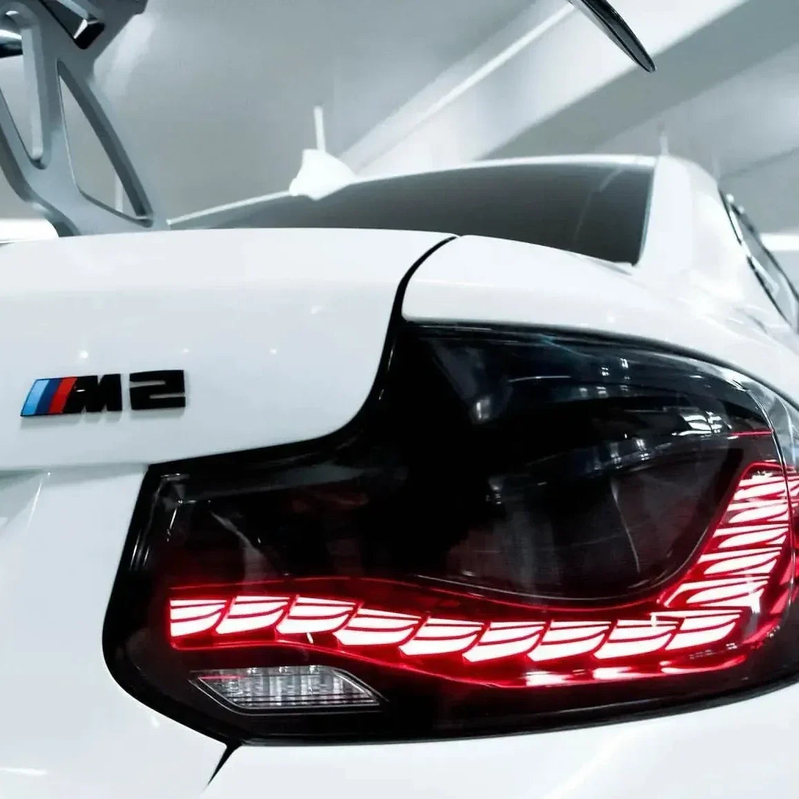 Fehér BMW F87 M2 világító GTS Style OLED hátsó lámpája közelről, ferdén