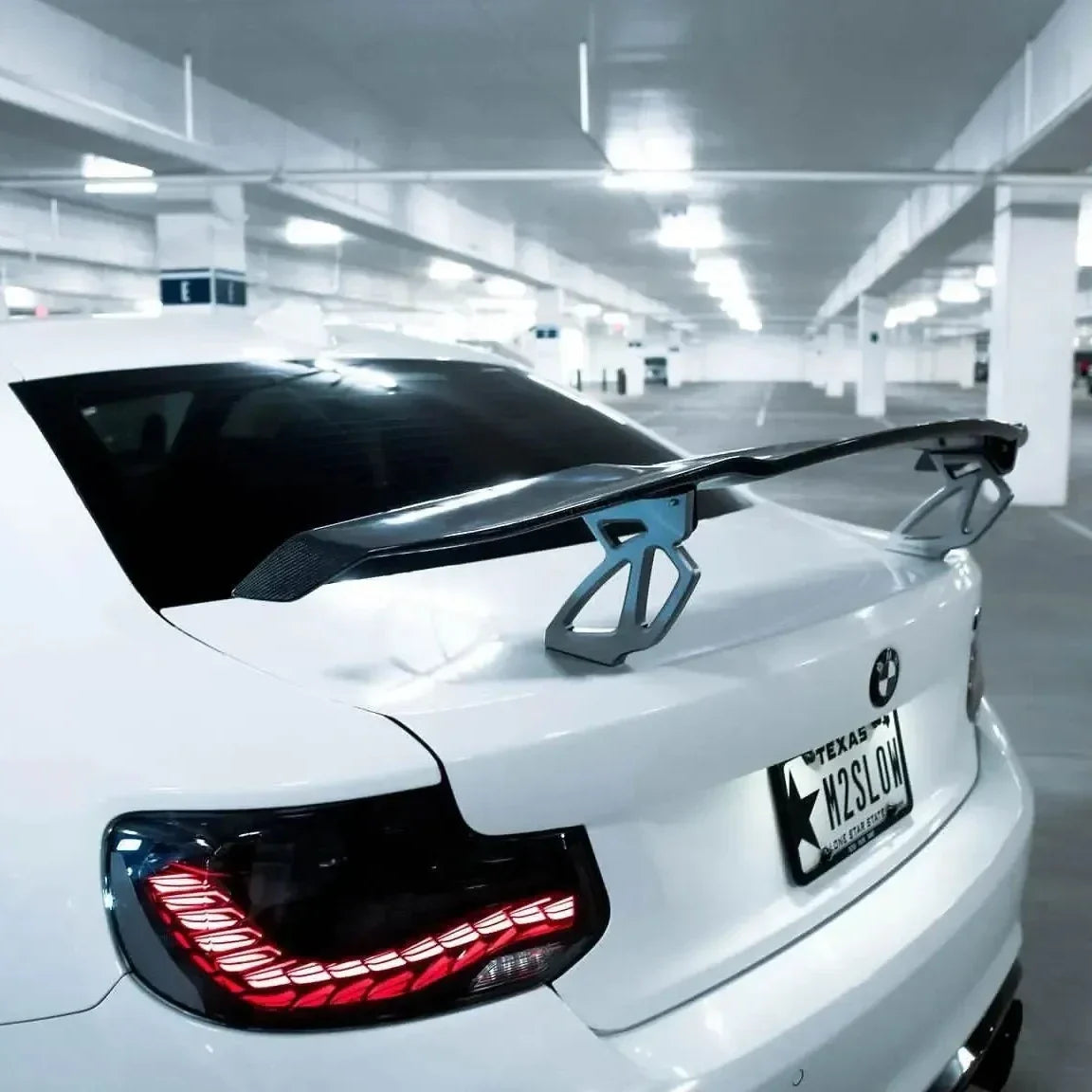 Fehér BMW F87 M2 hátsó sarka közelről, világító GTS Style OLED hátsó lámpával