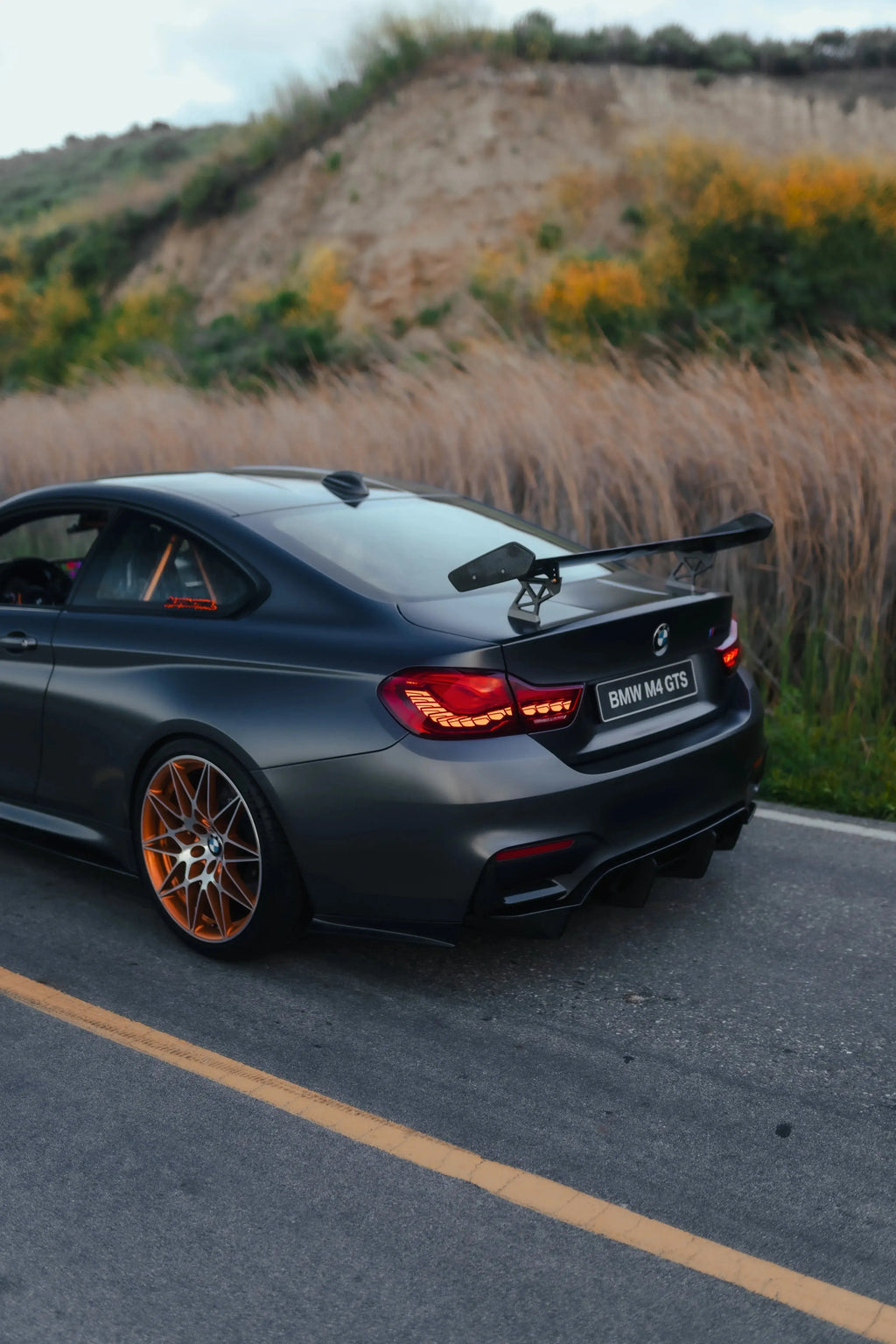 Szürke BMW F82 M4 GTS hátsó háromnegyed nézetből, GTS Style carbon hátsó szárnnyal