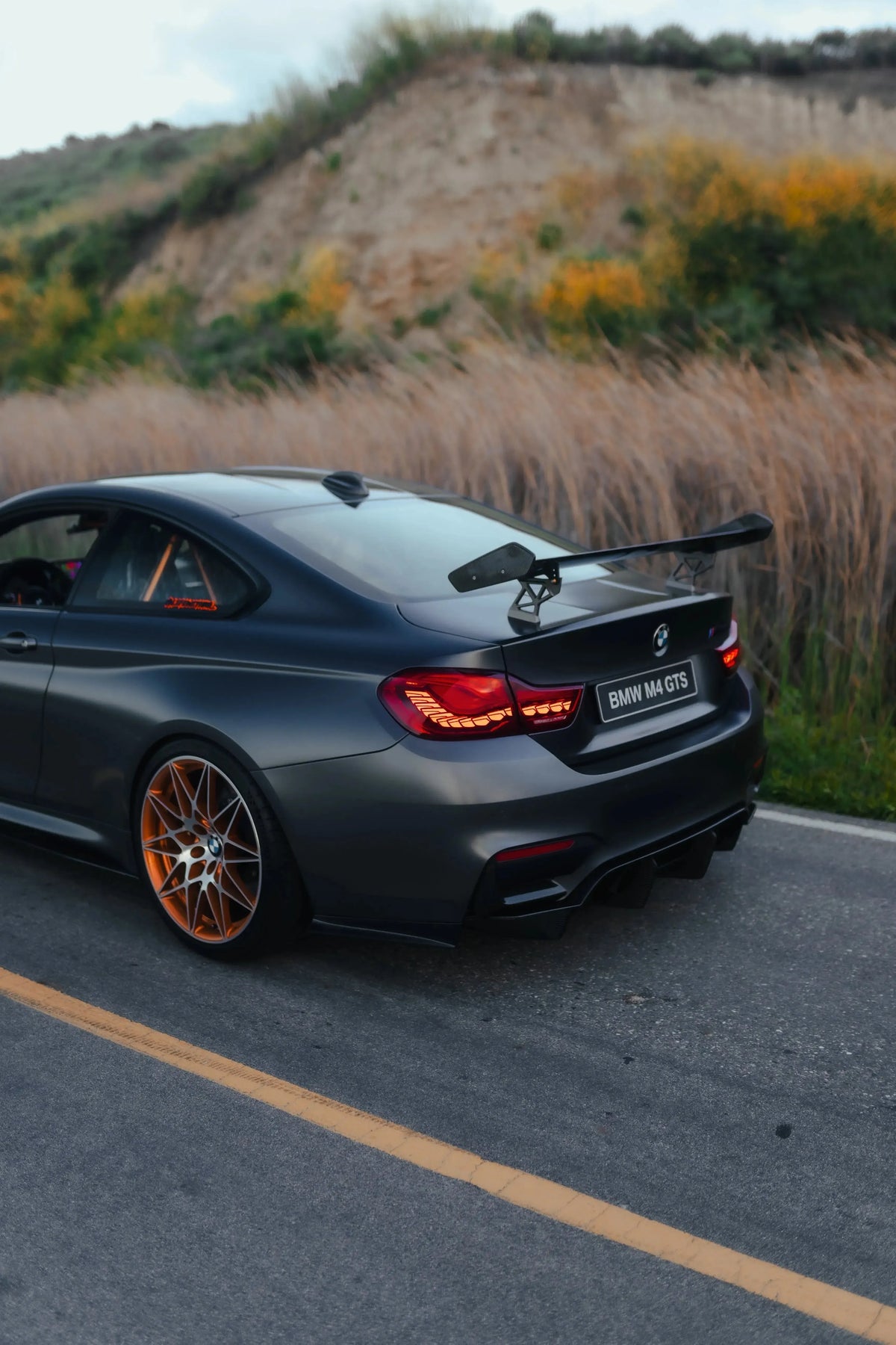 Szürke BMW F82 M4 GTS hátsó háromnegyed nézetből, GTS Style carbon hátsó szárnnyal