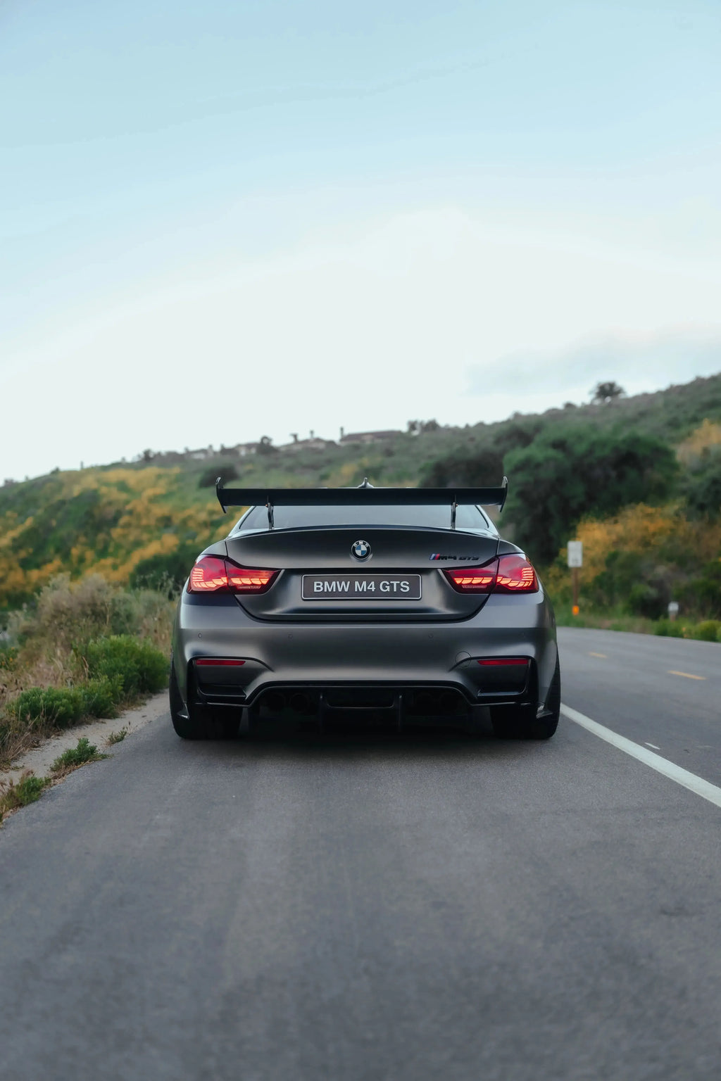 Szürke BMW F82 M4 GTS hátulról az úton, felszerelt GTS Style carbon hátsó szárnnyal