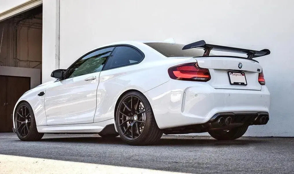 Fehér BMW F87 M2 Competition hátulról ferdén, felszerelt MP Style carbon hátsó szárnnyal
