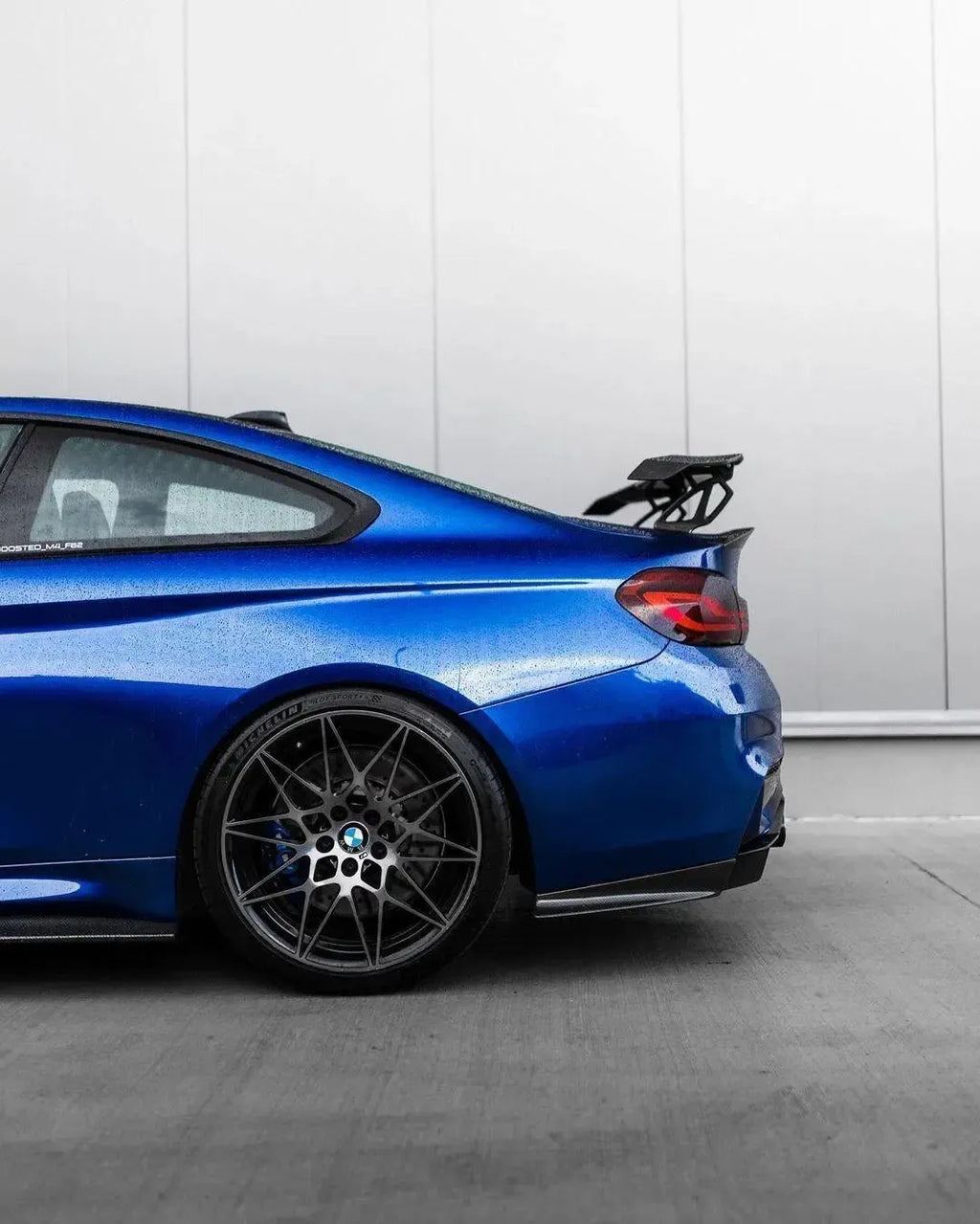 Kék BMW F82 M4 oldalnézetből, felszerelt V Style carbon hátsó szárnnyal