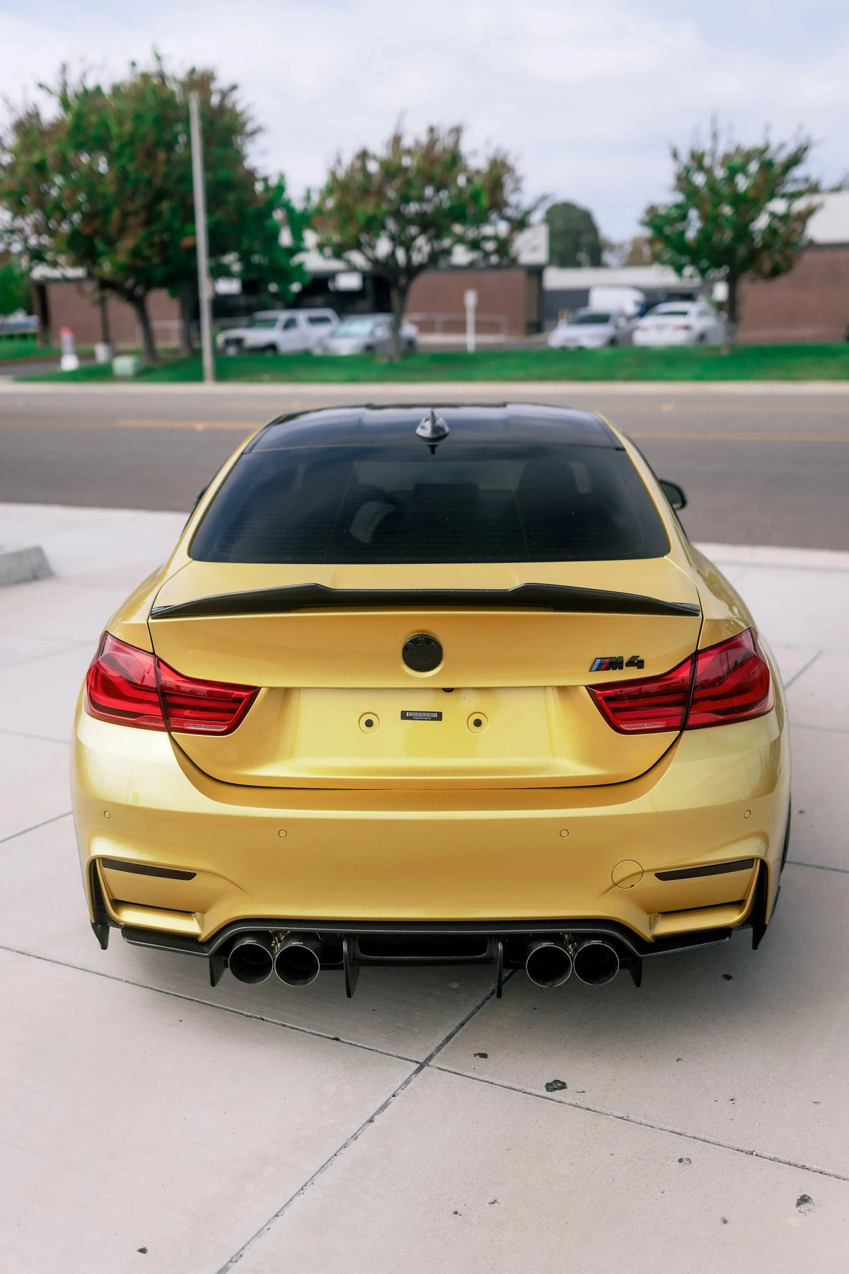 Arany BMW F82 M4 hátulról, felszerelt polírozott rozsdamentes acél kipufogóvégekkel