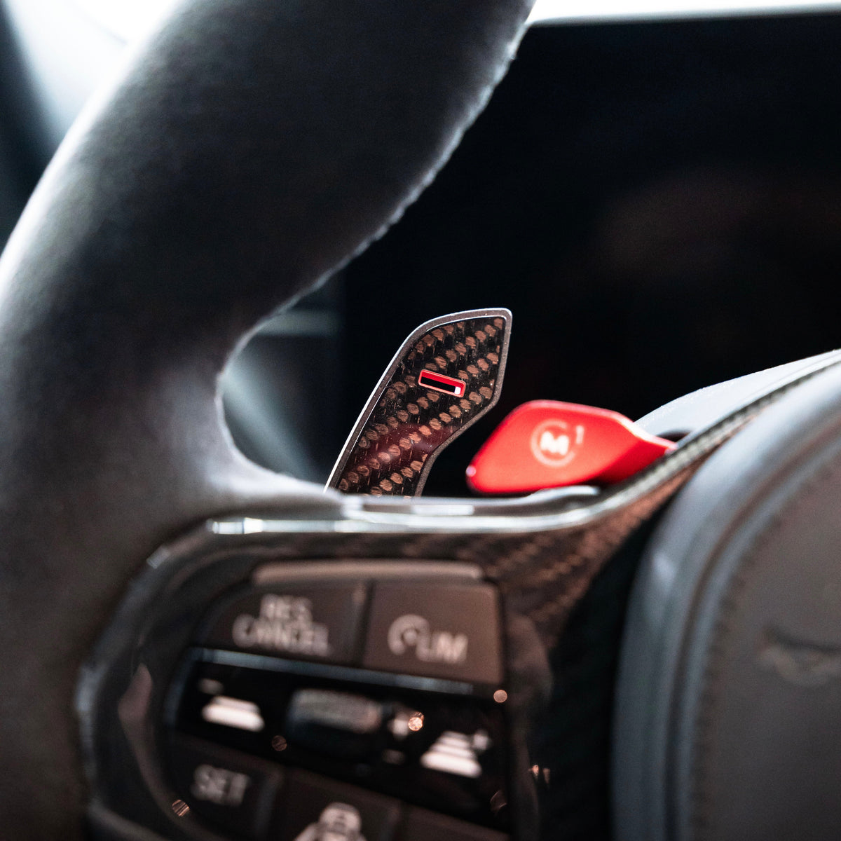 Clip-on carbon “−” paddle shifter with red marking, fitted on a BMW G Series M steering wheel