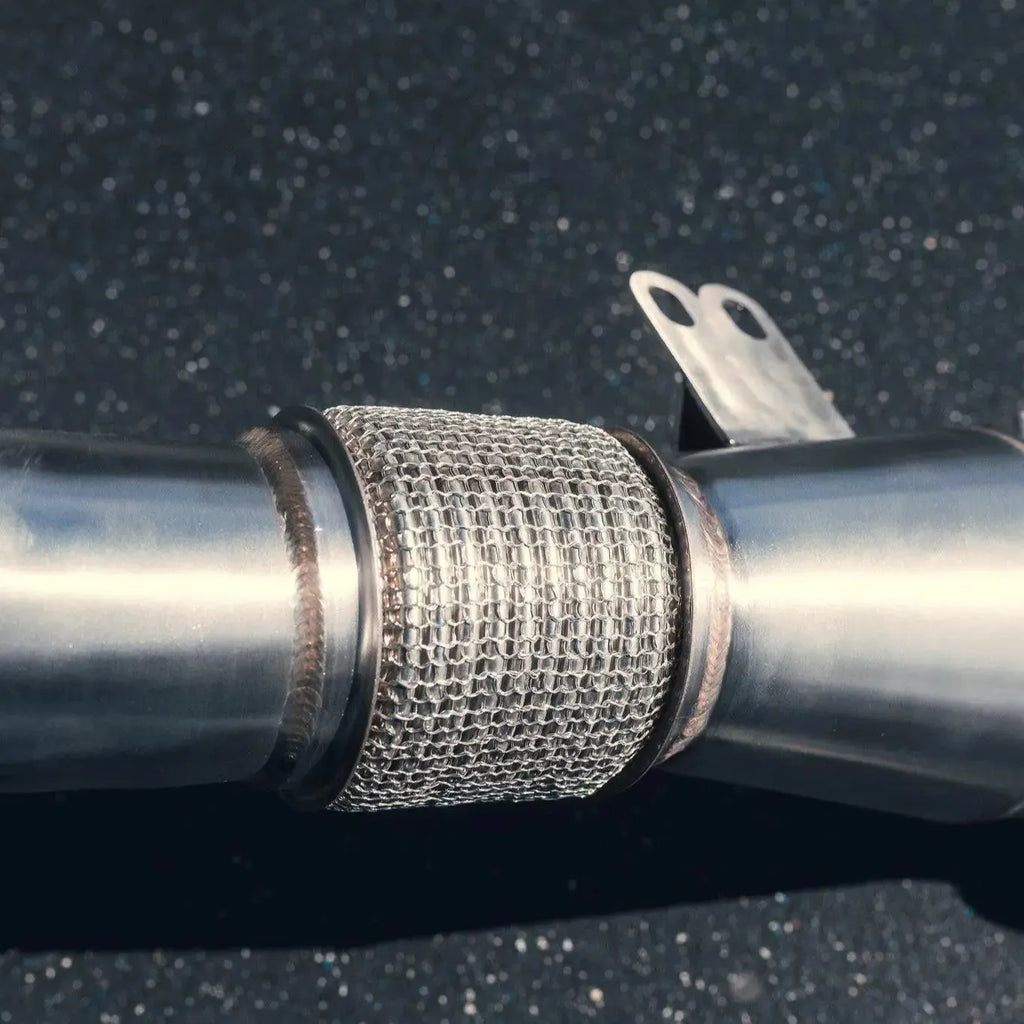 Racing downpipe close-up with braided flex section and support bracket – BMW G20 M340i