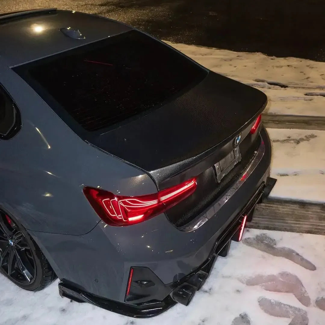Close-up of a gray BMW G20 rear in the snow, with fitted carbon trunk lid (CSL Style)