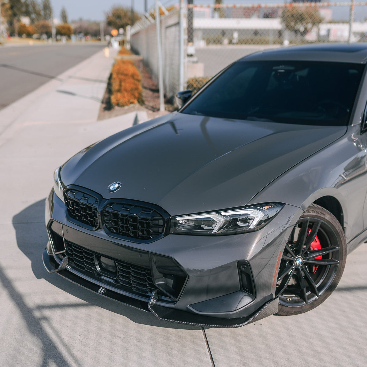 Gray BMW G20 LCI front left close-up: carbon front lip under the bumper (AD Style)