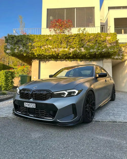 Gray BMW G20 LCI, front three-quarter view, with fitted carbon fiber front lip (MP Style)