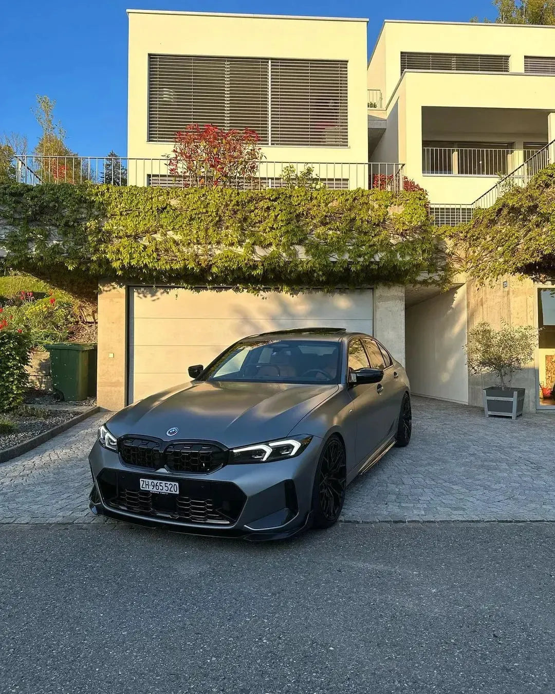 Gray BMW G20 LCI from a low front three-quarter angle, with fitted carbon front lip (MP Style)