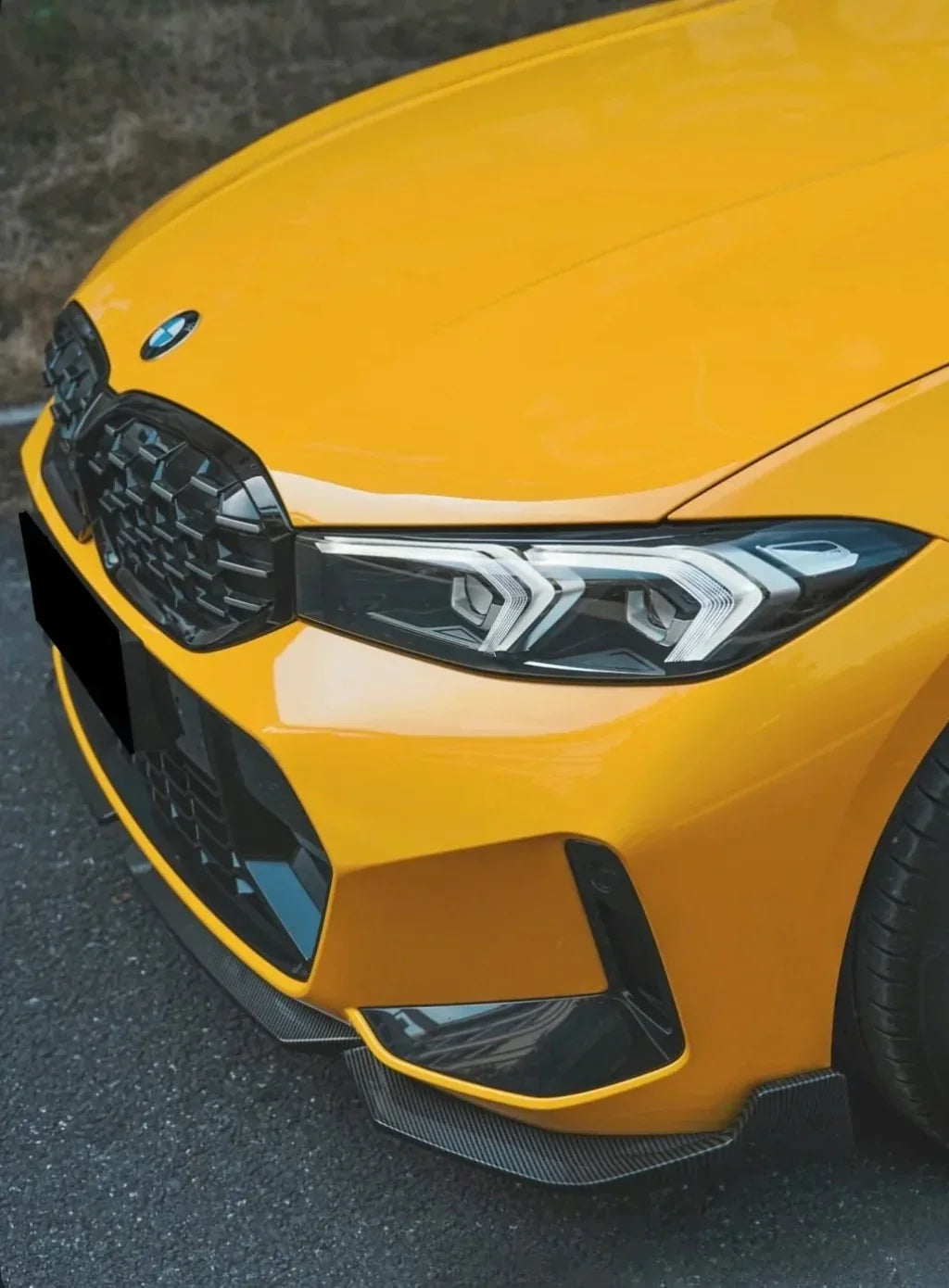Yellow BMW G20 LCI front three-quarter close-up, with fitted carbon front lip (Performance Style)