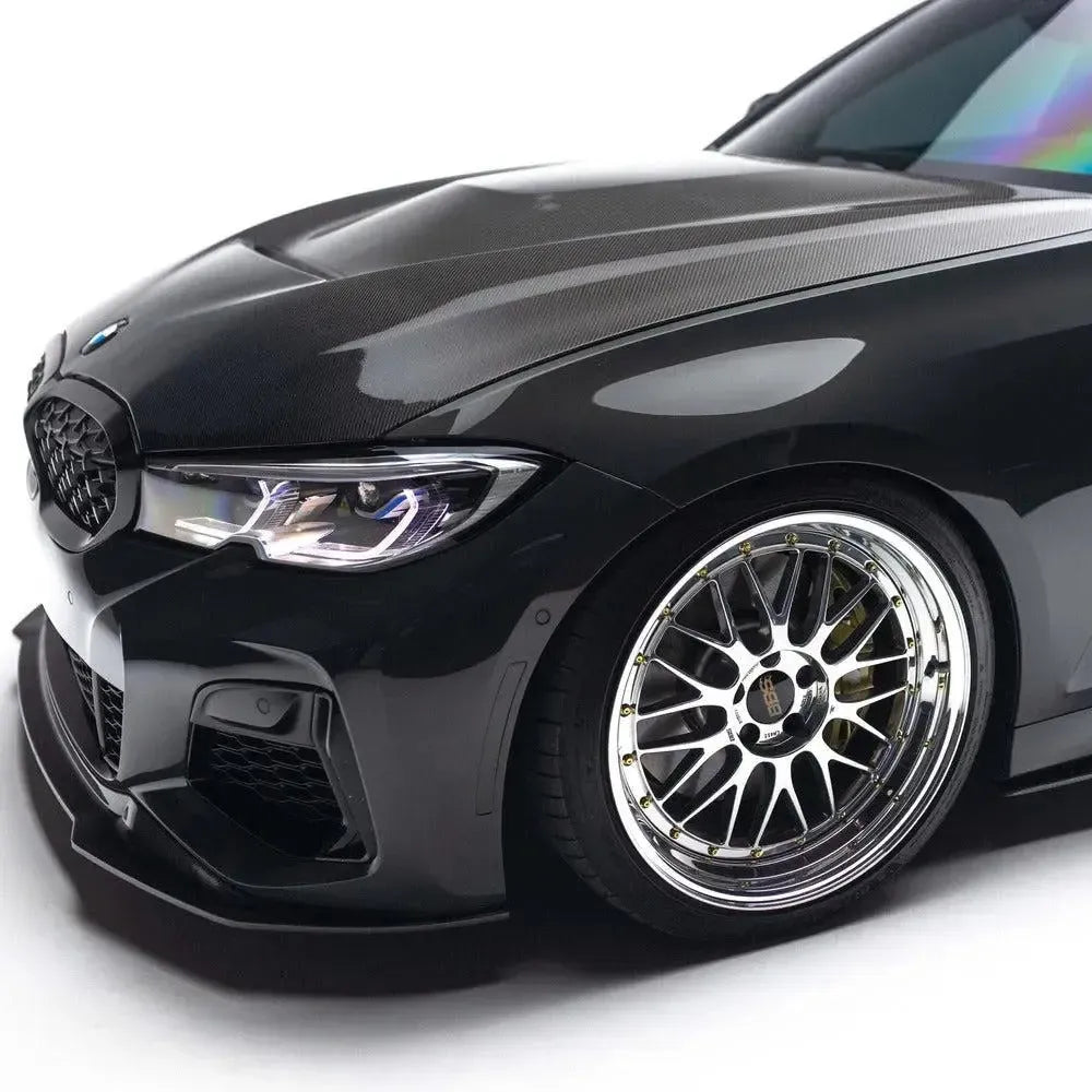 Black BMW G20 M340i front three-quarter close-up, carbon front lip with side wings, silver wheel (V Style V2)