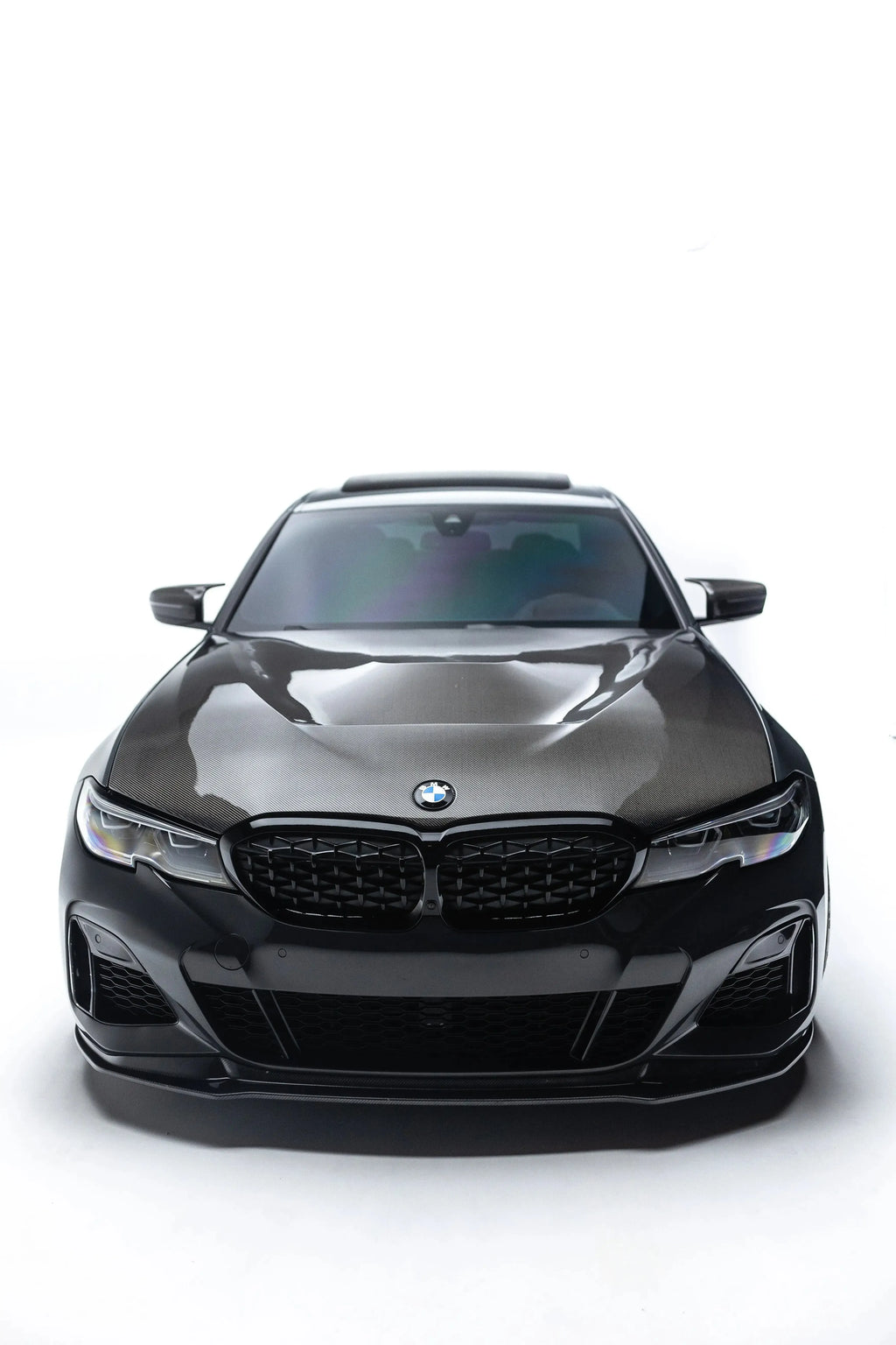 Black BMW G20 M340i head-on, against a white background, with fitted carbon front lip (V Style V2)