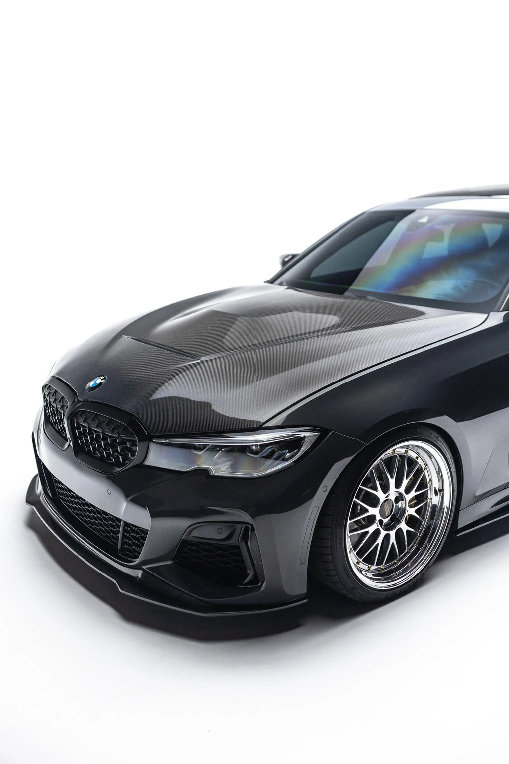 Black BMW G20 M340i from a low front three-quarter angle, with carbon front lip with side wings (V Style V2)