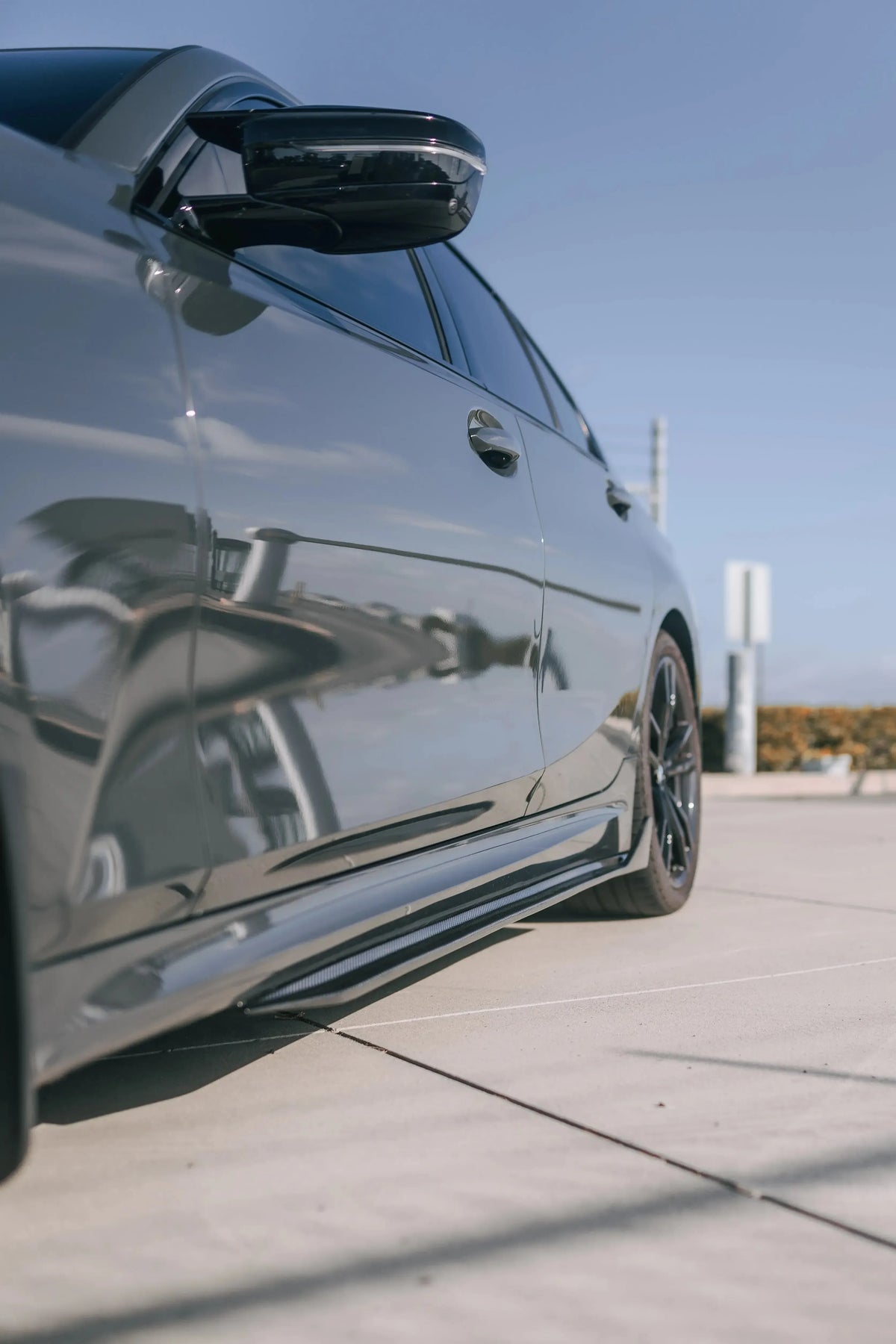 Close-up of a gray BMW G20 side with fitted carbon side skirt (TK Style)