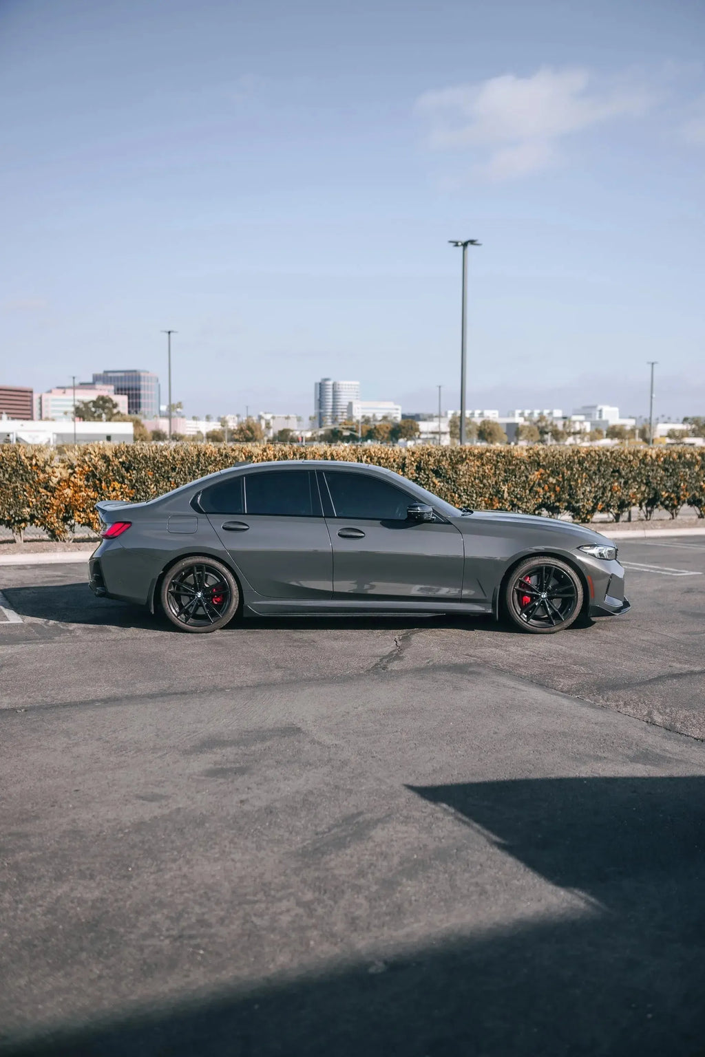 Full side profile of a gray BMW G20 with fitted carbon side skirts (TK Style)
