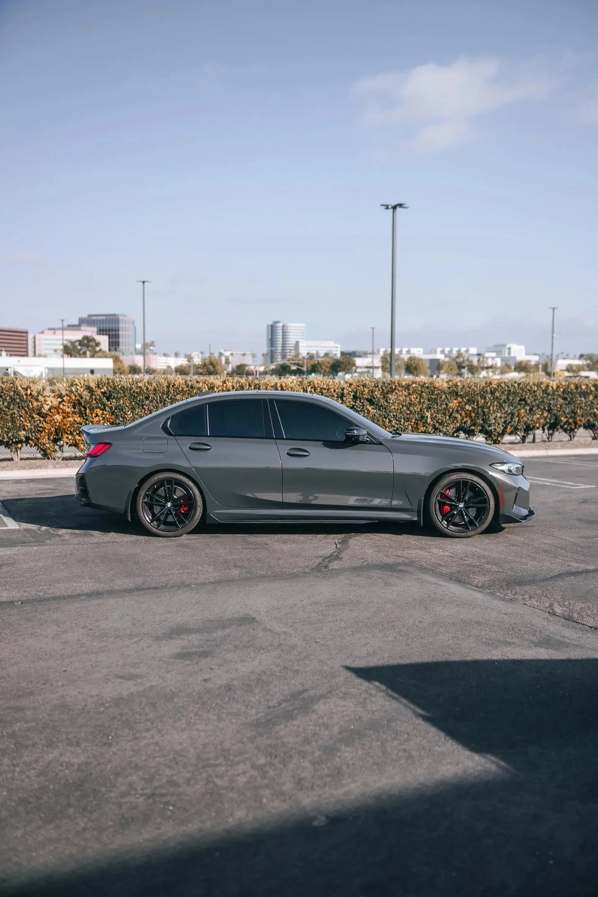 Full side profile of a gray BMW G20 with fitted carbon side skirts (TK Style)