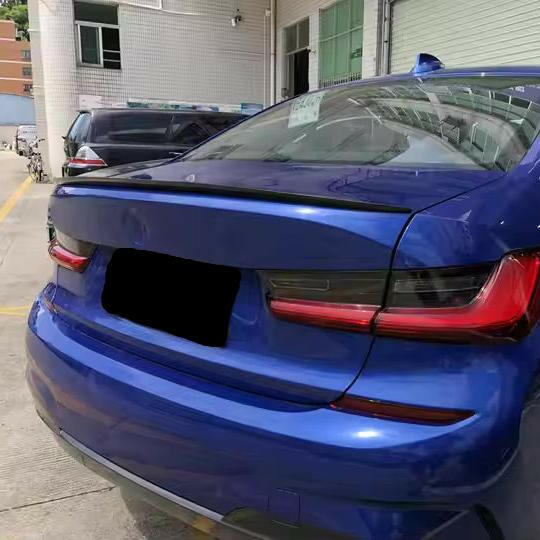 Blue BMW G20 rear, three-quarter view, with slim carbon trunk spoiler (M Style)