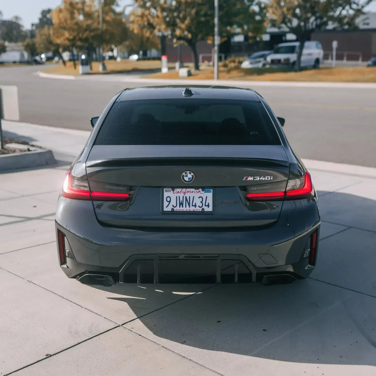 Gray BMW G20 M340i LCI from the rear, with fitted carbon trunk spoiler (MP Style)