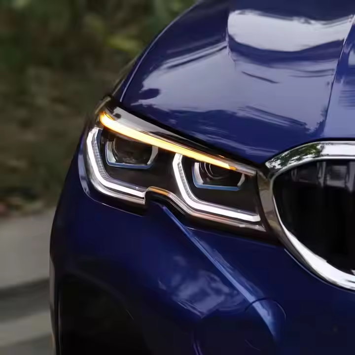 Close-up of a blue BMW G20 headlight, white DRL and amber upper strip (Dual-Color Laser Style)