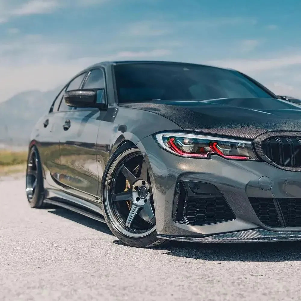 LED headlights lit with red DRL on the front of a gray pre-LCI BMW G20, low three-quarter view (Laser Style)