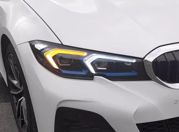 Close-up of the front of a white pre-LCI BMW G20, headlight with yellow and white DRL (LCI Style)