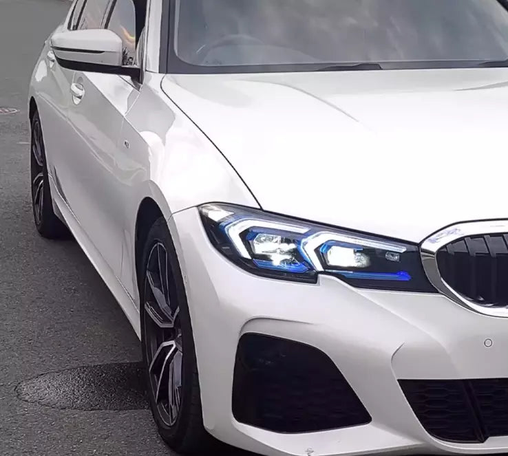 White BMW G20 in front three-quarter view, headlight with white DRL and blue insert (LCI Style)