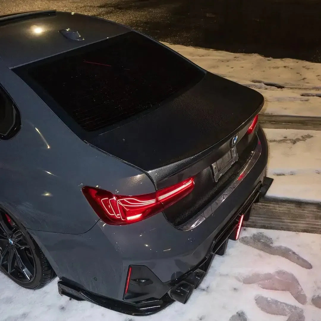 Szürke BMW G20 hátulról 3/4-ben a hóban, piros hátsó lámpák közelről (CSL Style V1)